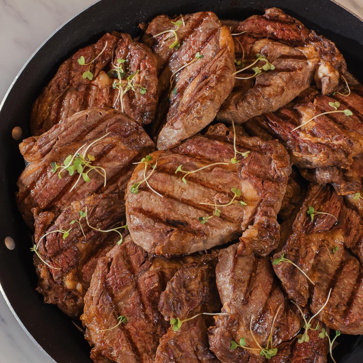 Cortes de carne grelhados em panela de ferro, finalizados com microverdes