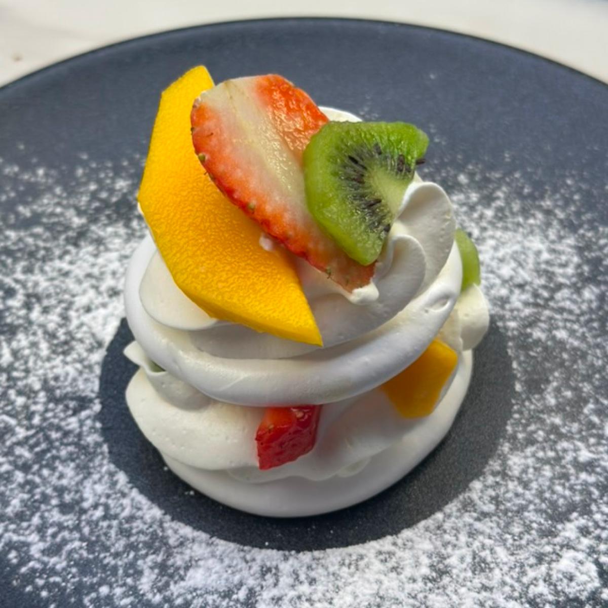 Merengue com chantilly, manga, morango e kiwi